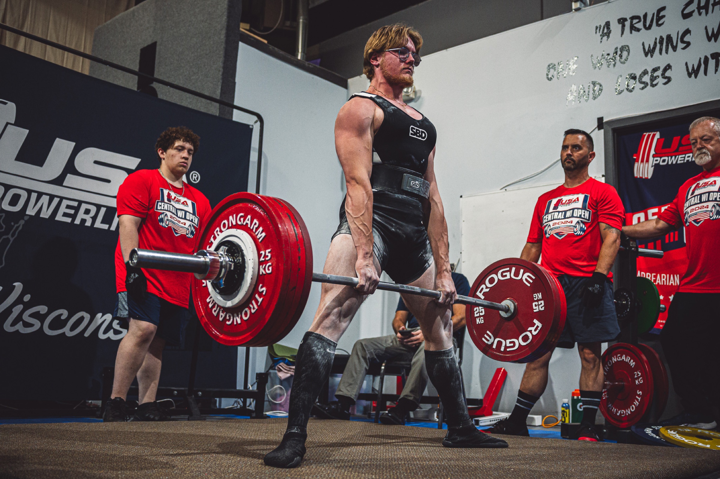 Powerlifter completing a deadlift on the competition platform